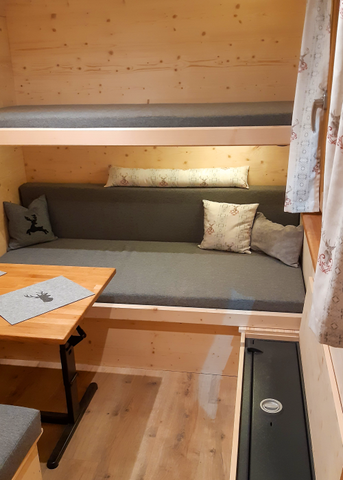 Zusätzliche Stauräume unter den Bänken und als Sideboard. Absenkbarer Esstisch für eine Liegefläche von 1,40m Breite. Zusätzliches klappbares Bett für eine Liegefläche von 0,80m Breite und fest eingebauter sowie verkleideter Waffenschrank (Klasse 0 für bis zu drei Langwaffen).