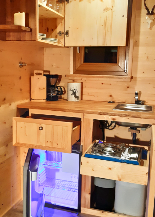 DIe Küche ist mit einem Kühlschrank (230 V/ 12 V/ Gas Betrieb), gasbetriebener Ofen und Gaskochfeld (transportabel und fest eingebaut möglich) ausgestattet.